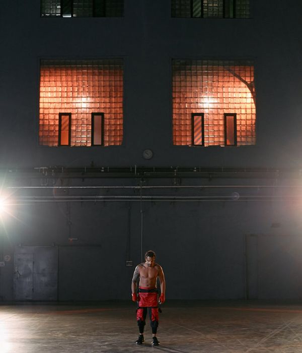Man performing a bodyweight exercise in a focused, powerful stance.